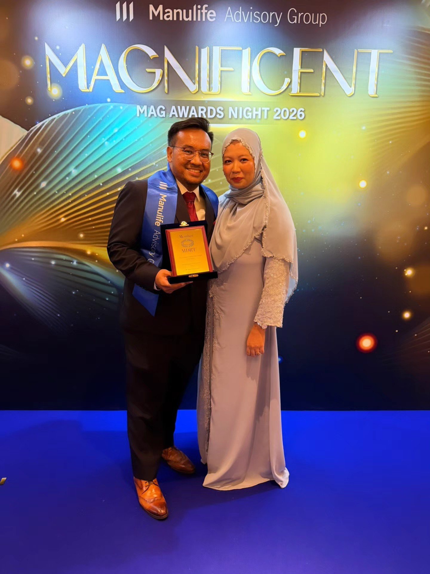 Syukri Ismail receiving his MDRT 2026 award at the Manulife Advisory Group Magnificent Mag Awards Night, with his wife